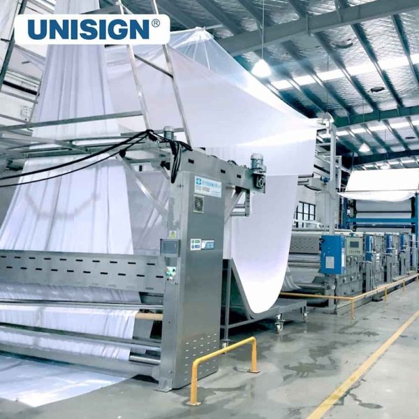White fabric moving through a UNISIGN textile production line